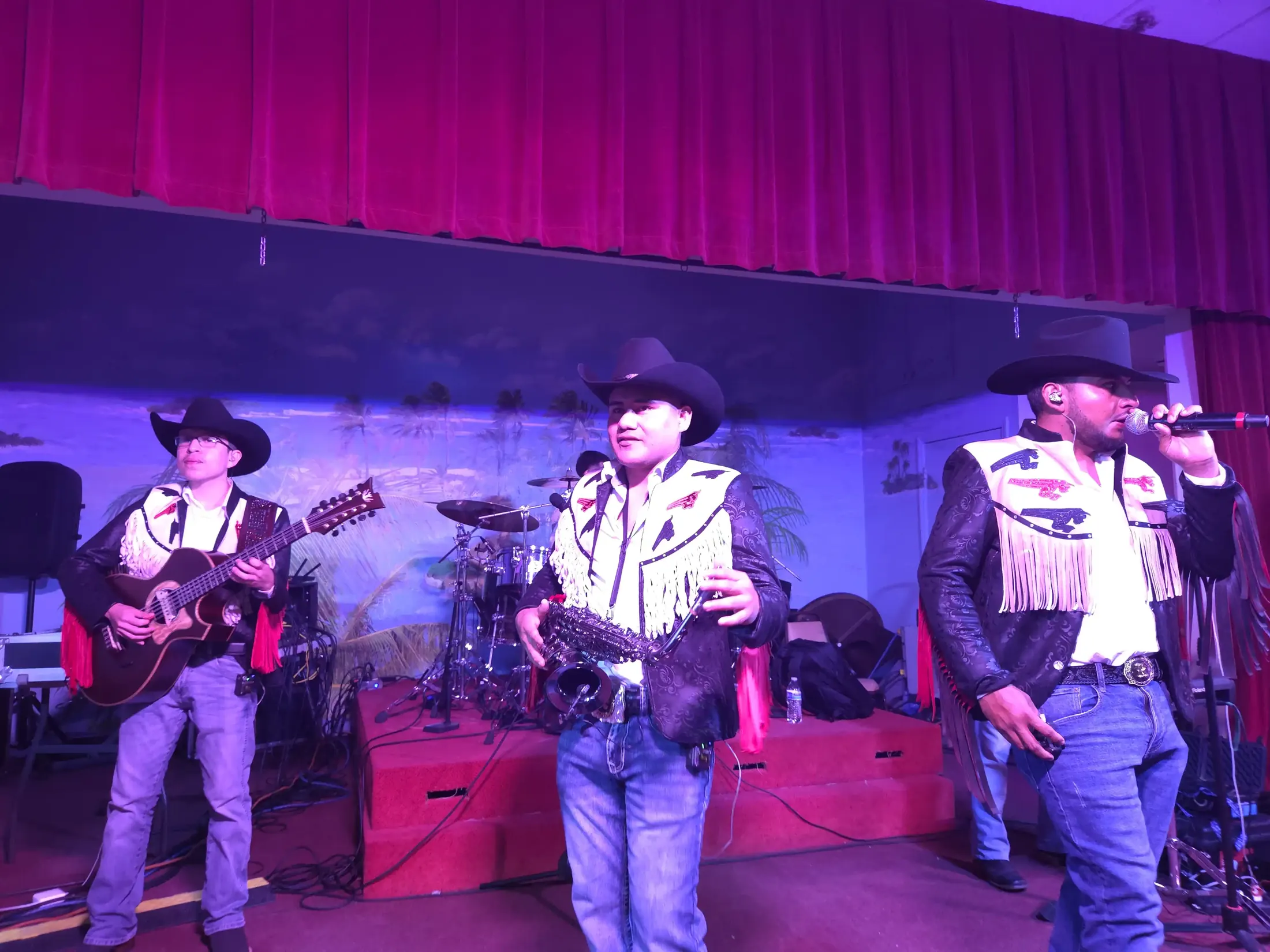 Conjunto Infinito tocando en el escenario con sus chaquetas de flecos